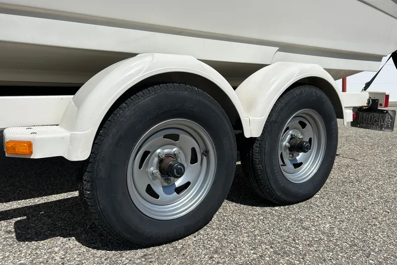 Slide: The Image of Trailer wheels of a 2005 Sea Ray 200 Sport boat on pavement. - 11