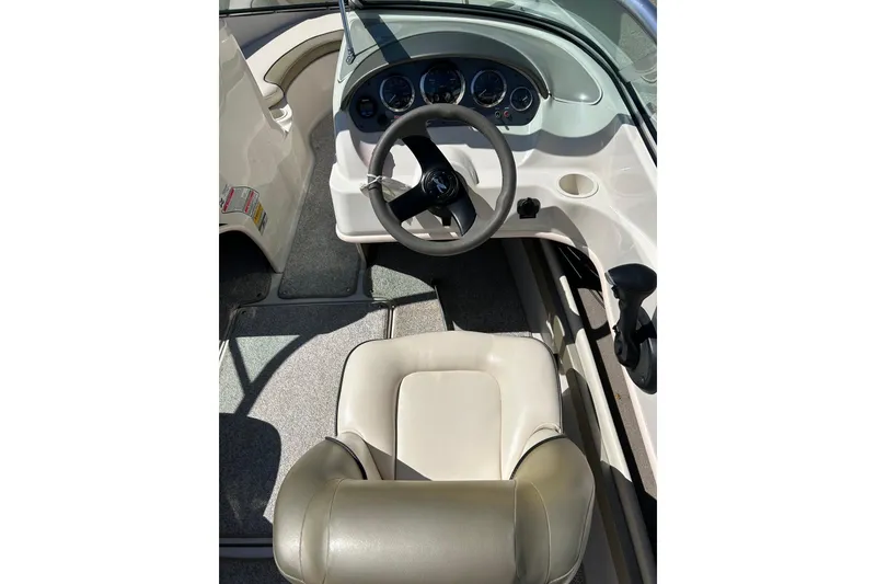 Slide: The Image of 2005 Sea Ray 200 Sport boat cockpit with steering wheel and beige seating. - 22