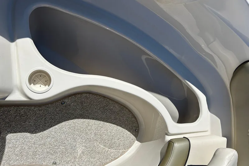 Slide: The Image of Interior detail of a 2005 Sea Ray 200 Sport boat, featuring storage compartment and cup holder. - 31