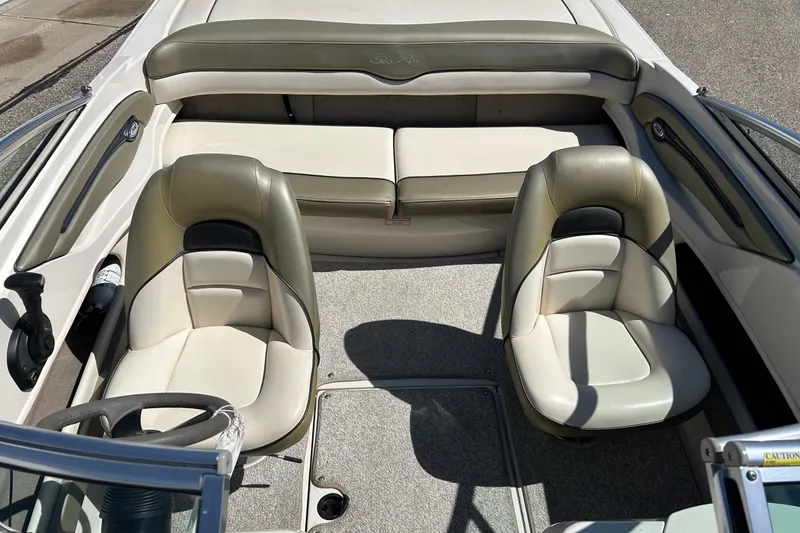 Slide: The Image of 2005 Sea Ray 200 Sport boat interior with beige seating and steering wheel. - 34