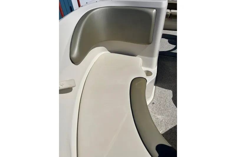 Slide: The Image of 2005 Sea Ray 200 Sport boat interior seating, featuring beige and gray upholstery. - 36