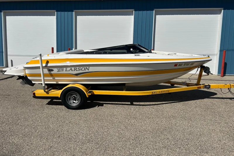 The Image of 2007 Larson SEi 180 LX I/O boat on yellow trailer, parked outdoors. - 0