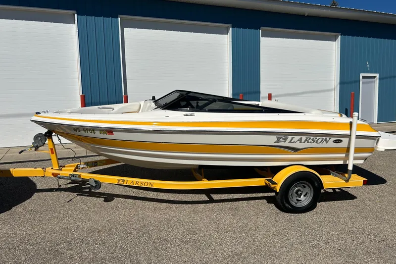 Slide: The Image of 2007 Larson SEi 180 LX I/O boat on yellow trailer, parked outside blue building. - 15