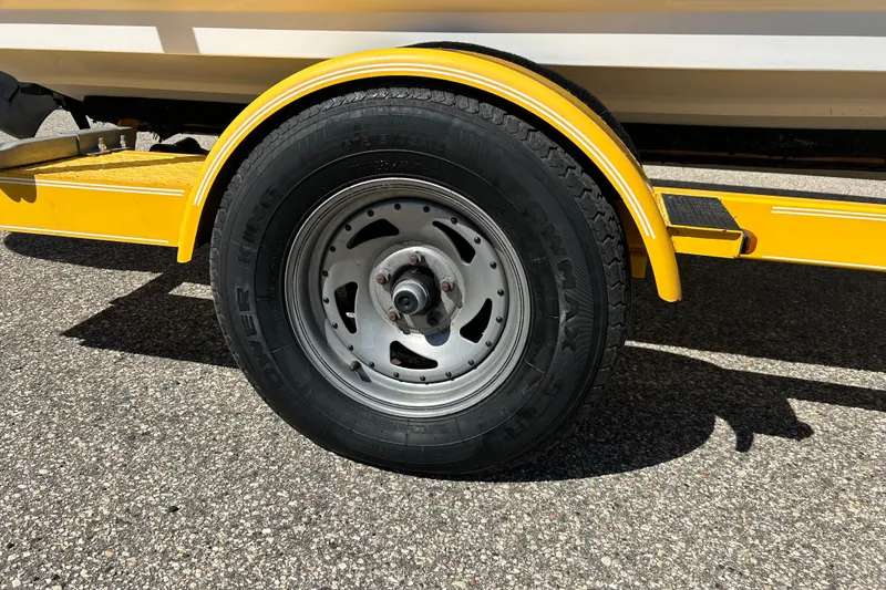 Slide: The Image of Yellow trailer wheel of 2007 Larson SEi 180 LX I/O boat on asphalt. - 4