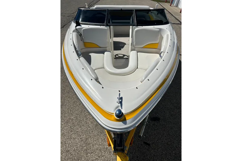 Slide: The Image of 2007 Larson SEi 180 LX I/O boat with white and yellow interior, docked on pavement. - 5