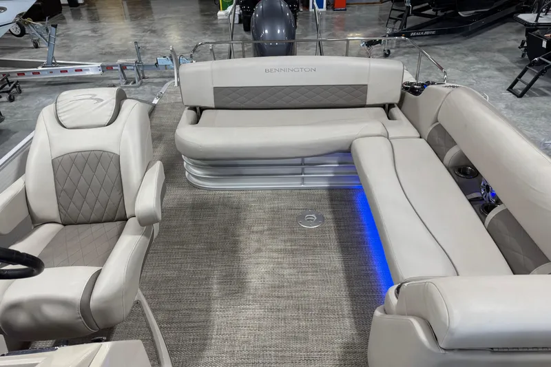 Slide: The Image of 2018 Bennington S 25 boat interior with beige seating and blue LED lighting. - 11
