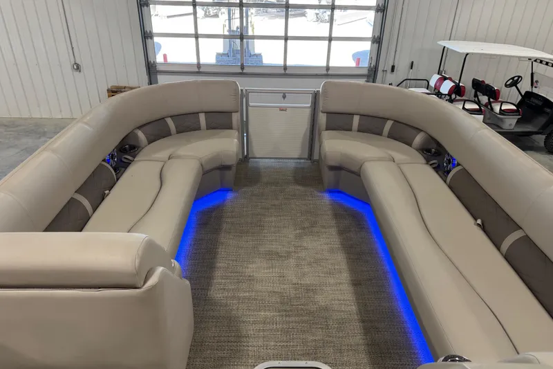 Slide: The Image of 2018 Bennington S 25 pontoon boat interior with beige seating and blue LED lighting. - 12