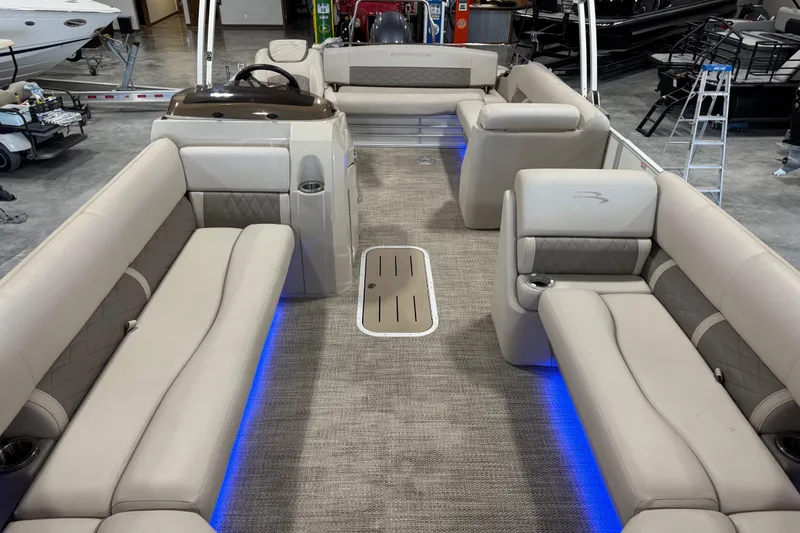 Slide: The Image of 2018 Bennington S 25 pontoon boat interior with beige seating and blue LED lighting. - 15