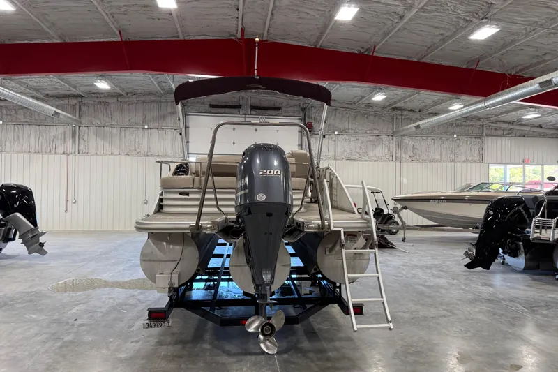 Slide: The Image of 2018 Bennington S 25 pontoon boat in a showroom with Yamaha 200 engine. - 22