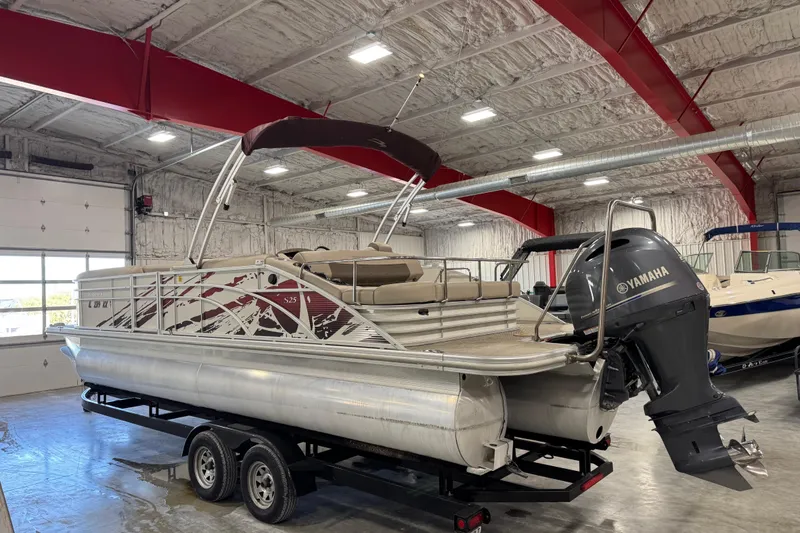 Slide: The Image of 2018 Bennington S 25 pontoon boat with Yamaha engine in a spacious indoor storage facility. - 4