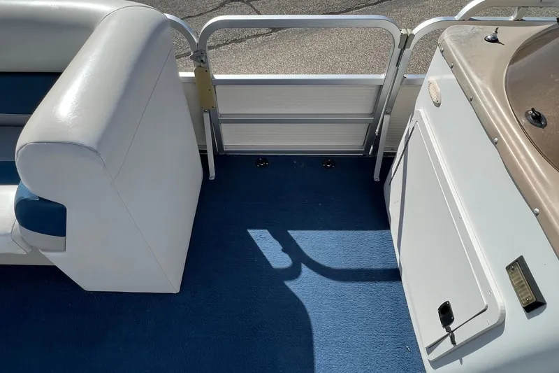 Slide: The Image of 2003 Sylvan 824 Mirage Cruise interior with blue carpet and white seating. - 10
