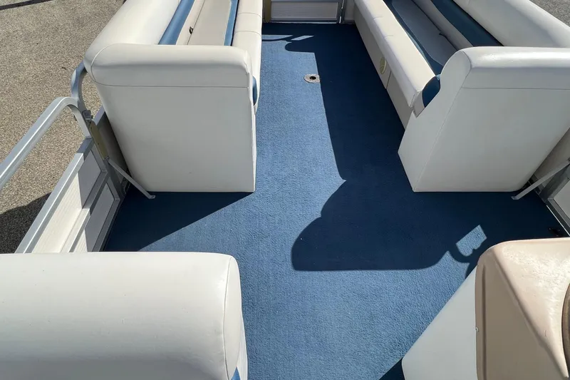 Slide: The Image of Interior of 2003 Sylvan 824 Mirage Cruise boat with blue carpet and white seating. - 11