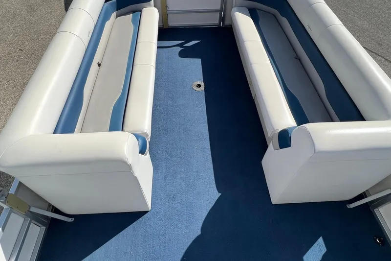 Slide: The Image of 2003 Sylvan 824 Mirage Cruise interior with blue carpet and white seating. - 12