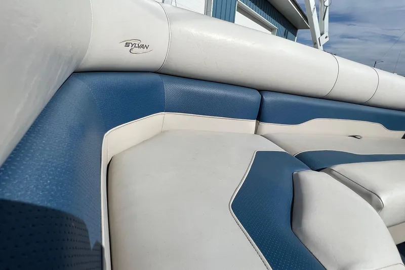 Slide: The Image of 2003 Sylvan 824 Mirage Cruise boat interior with blue and white cushioned seating. - 17