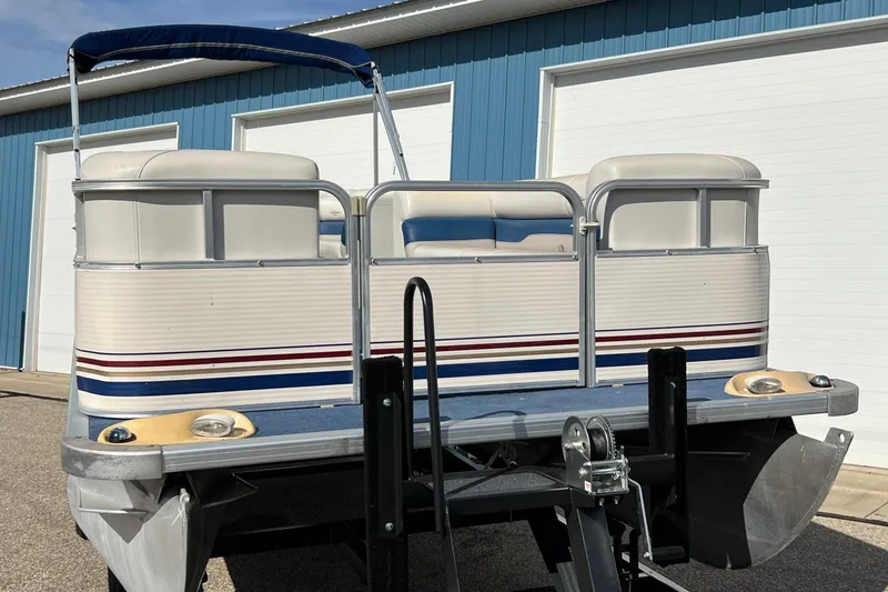 Slide: The Image of 2003 Sylvan 824 Mirage Cruise pontoon boat with blue and white exterior, docked outdoors. - 4