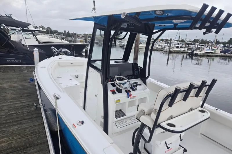 Slide: The Image of 2021 Sea Hunt Gamefish 25 boat docked at marina, featuring modern helm and seating. - 10