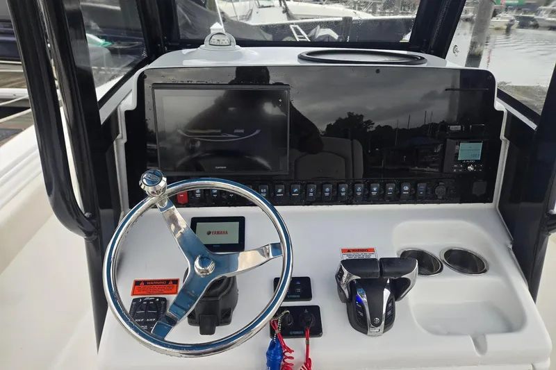 Slide: The Image of 2021 Sea Hunt Gamefish 25 dashboard with steering wheel and control panel. - 11