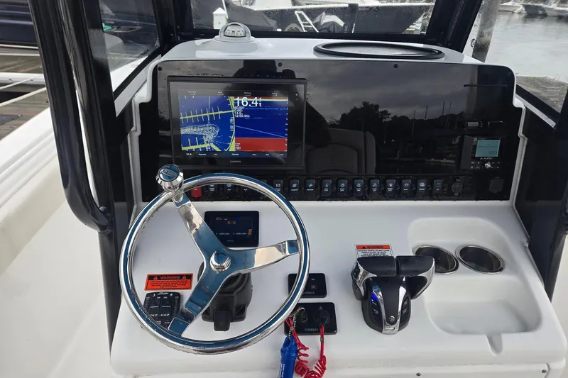 Slide: The Image of 2021 Sea Hunt Gamefish 25 dashboard with steering wheel, navigation display, and controls. - 14