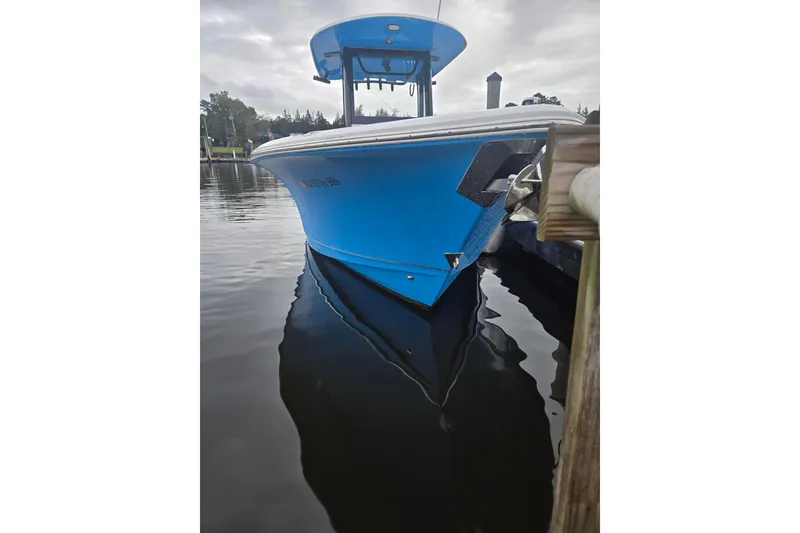 Slide: The Image of 2021 Sea Hunt Gamefish 25 boat docked on calm water, overcast sky. - 4