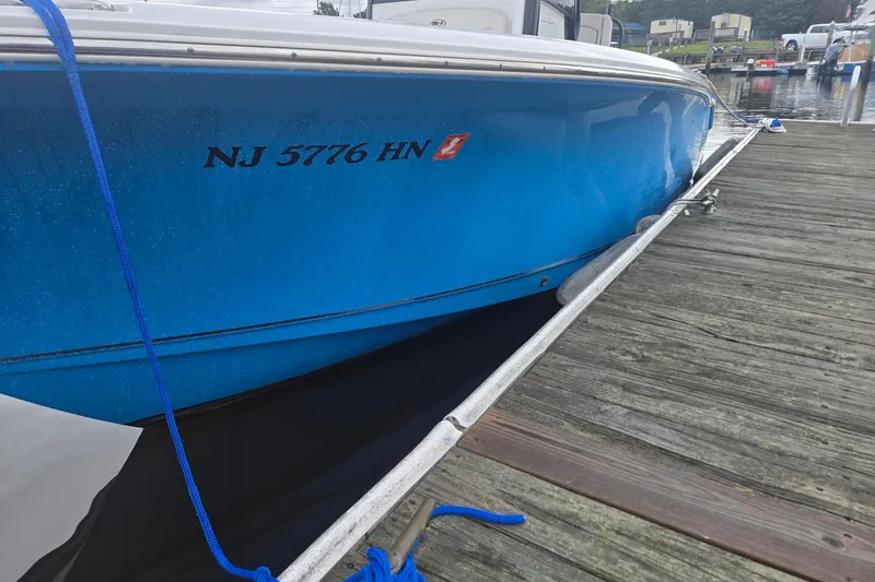 Slide: The Image of 2021 Sea Hunt Gamefish 25 boat docked, blue hull, registration NJ 5776 HN. - 8