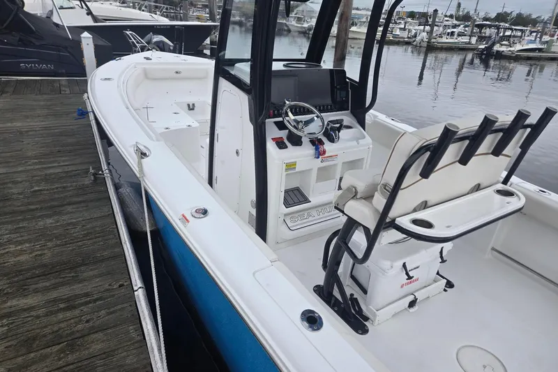 Slide: The Image of 2021 Sea Hunt Gamefish 25 boat docked, featuring helm and seating area. - 9