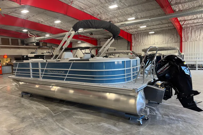Slide: The Image of 2026 Berkshire 24 RFX LE pontoon boat in showroom, featuring Mercury outboard motor. - 4