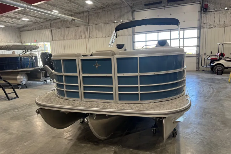 Slide: The Image of 2026 Berkshire 24 RFX LE pontoon boat in a showroom, featuring a sleek blue design. - 5