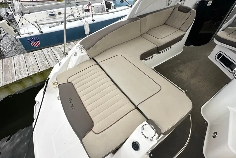 Slide: The Image of 2014 Sea Ray 280 Sundancer boat interior with beige seating at dock. - 12