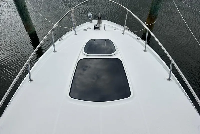 Slide: The Image of 2014 Sea Ray 280 Sundancer boat deck with hatches, docked on calm water. - 14