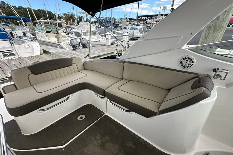 Slide: The Image of 2014 Sea Ray 280 Sundancer boat interior with beige seating at a marina. - 6