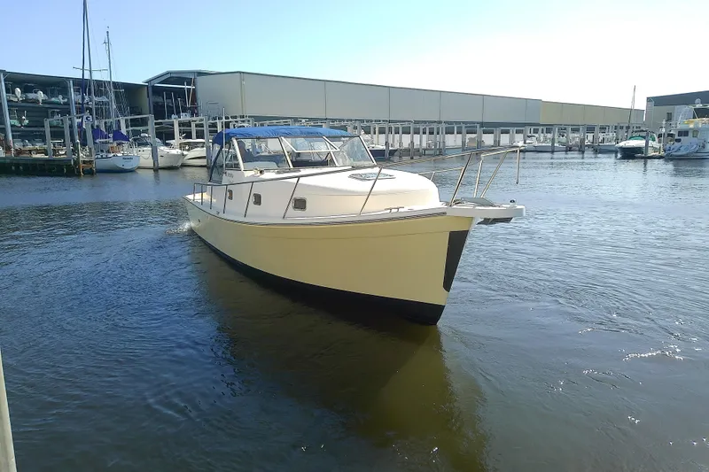 The Image of 2004 Mainship 34 Pilot II boat docked in a marina, surrounded by other vessels. - 0