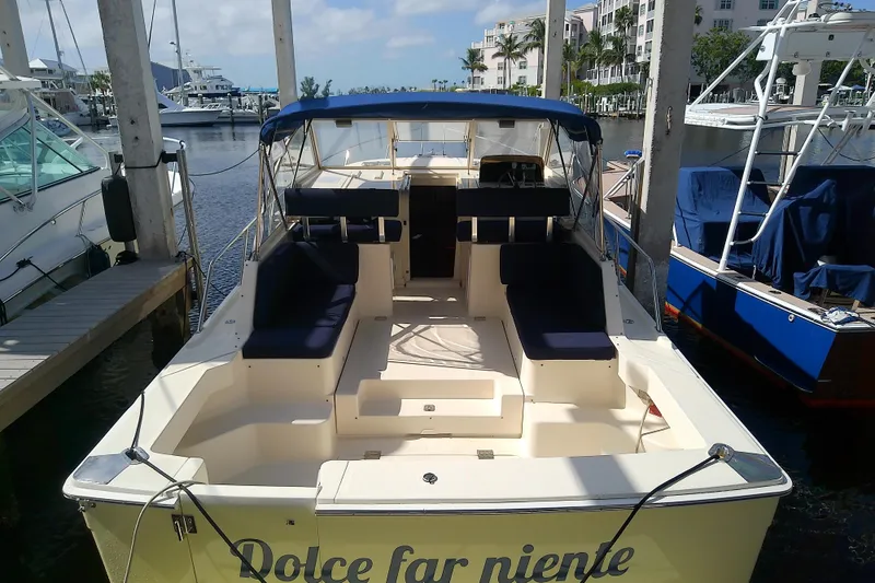 Slide: The Image of 2004 Mainship 34 Pilot II boat docked, featuring spacious seating and canopy. - 10