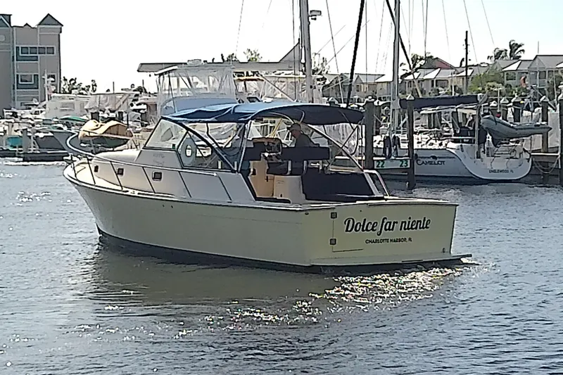 Slide: The Image of 2004 Mainship 34 Pilot II yacht named "Dolce far niente" in a marina setting. - 2