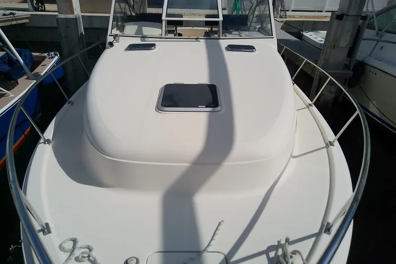 Slide: The Image of 2004 Mainship 34 Pilot II boat docked, showcasing its sleek deck and railing. - 22