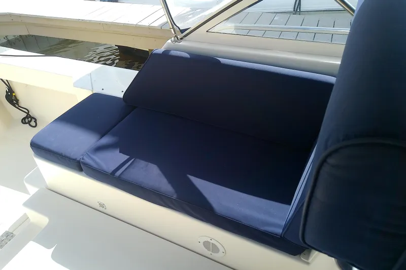 Slide: The Image of Blue cushioned seating on 2004 Mainship 34 Pilot II boat deck, under sunlight. - 34