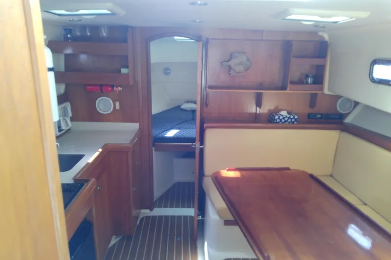 Slide: The Image of 2004 Mainship 34 Pilot II interior with wood cabinetry and cozy seating area. - 35
