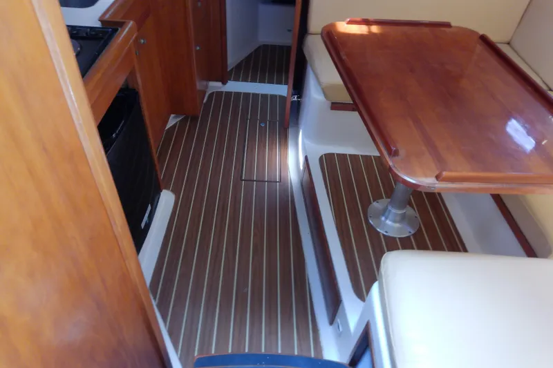 Slide: The Image of Interior of 2004 Mainship 34 Pilot II with wood flooring and dining area. - 36