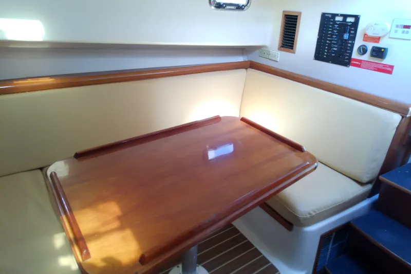 Slide: The Image of 2004 Mainship 34 Pilot II cabin with wooden table and cushioned seating. - 41