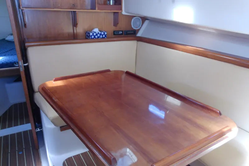 Slide: The Image of 2004 Mainship 34 Pilot II interior with wooden table and beige seating. - 43