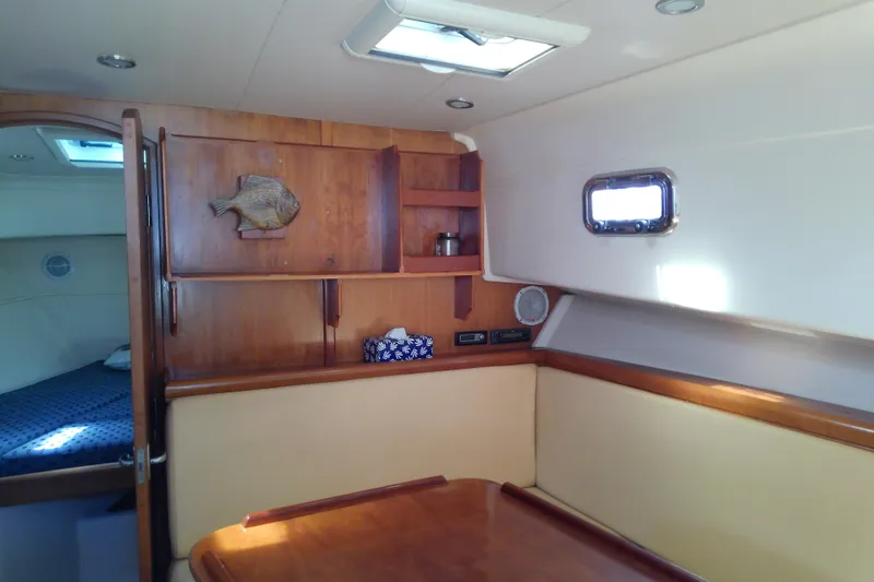 Slide: The Image of 2004 Mainship 34 Pilot II interior with wood cabinetry and cozy seating area. - 44
