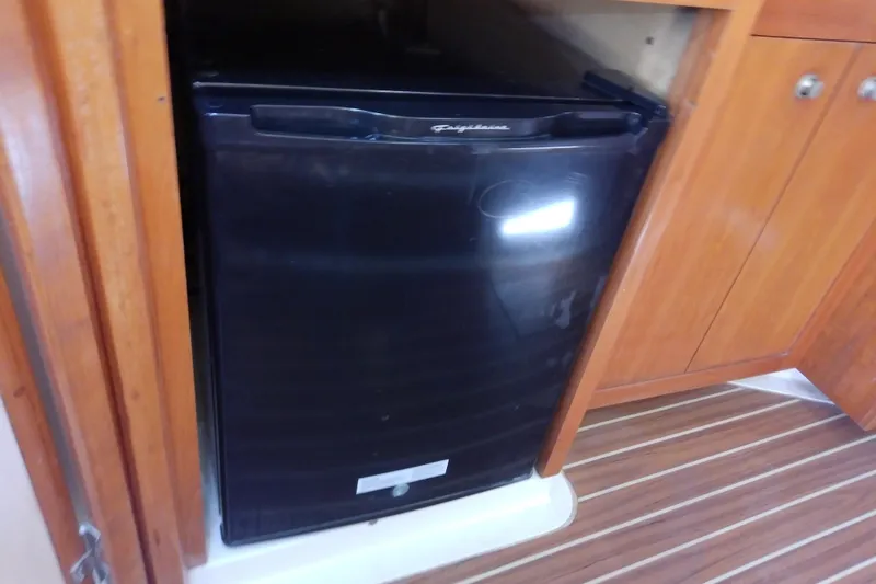 Slide: The Image of Black refrigerator in the cabin of a 2004 Mainship 34 Pilot II boat. - 48