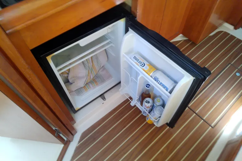 Slide: The Image of Open mini fridge on 2004 Mainship 34 Pilot II boat with drinks and towels inside. - 49