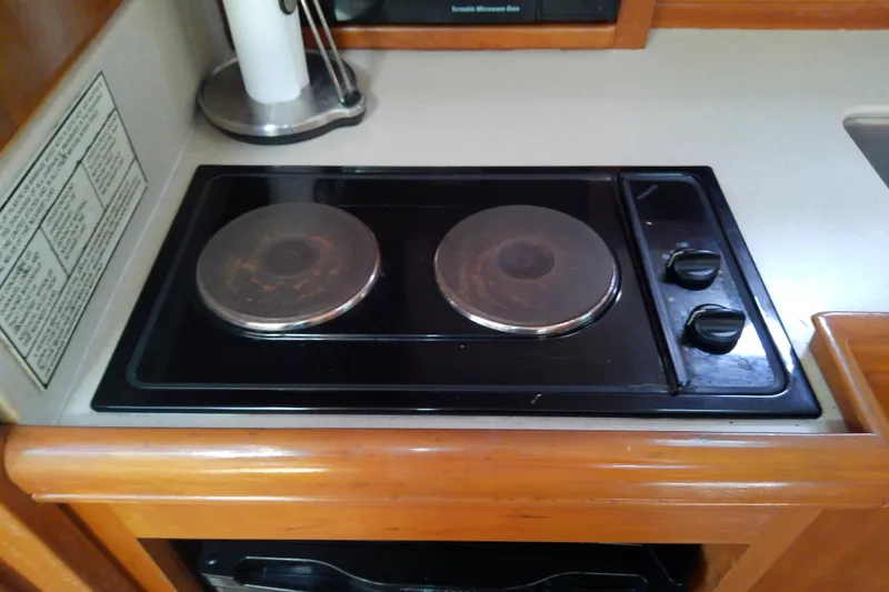 Slide: The Image of Electric stove in 2004 Mainship 34 Pilot II boat kitchen, featuring dual burners and control knobs. - 50