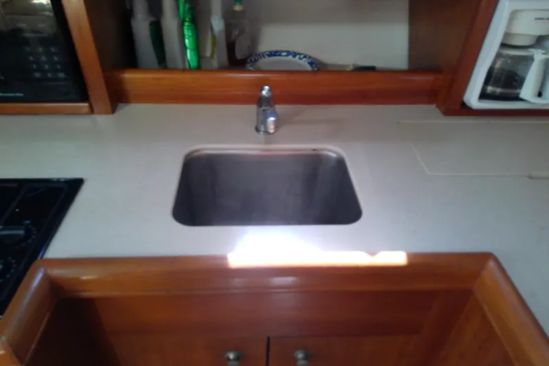 Slide: The Image of 2004 Mainship 34 Pilot II kitchen sink with wooden cabinetry and countertop. - 53