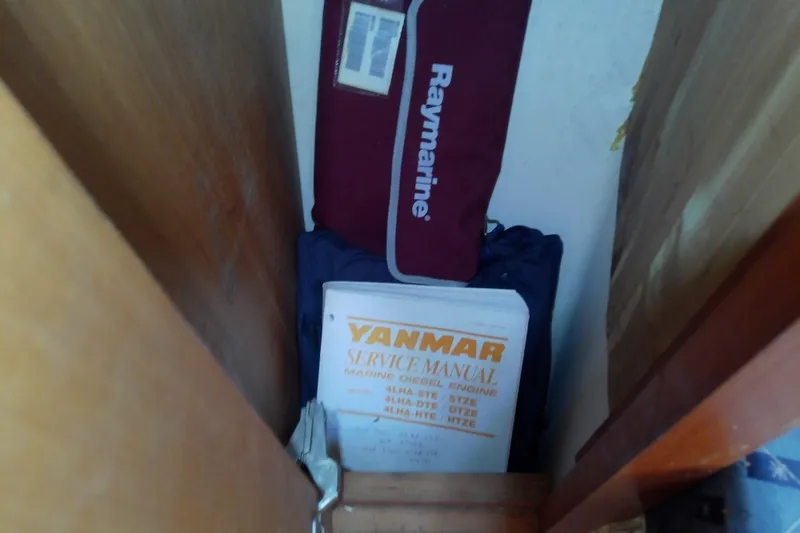 Slide: The Image of Storage area with Yanmar service manual and Raymarine bag on Mainship 34 Pilot II, 2004. - 57