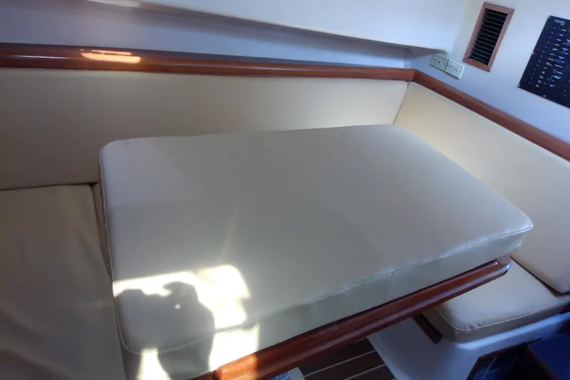 Slide: The Image of Interior seating area of a 2004 Mainship 34 Pilot II boat with beige cushions. - 59