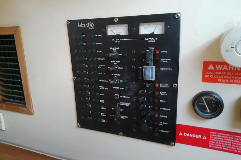 Slide: The Image of Electrical control panel on a 2004 Mainship 34 Pilot II boat, featuring various switches and gauges. - 60