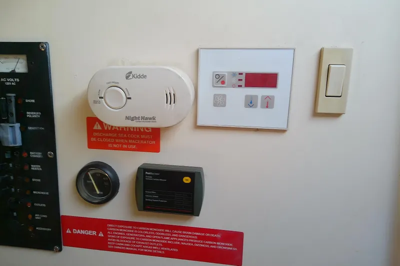 Slide: The Image of Control panel with safety warnings and devices on a 2004 Mainship 34 Pilot II boat. - 61