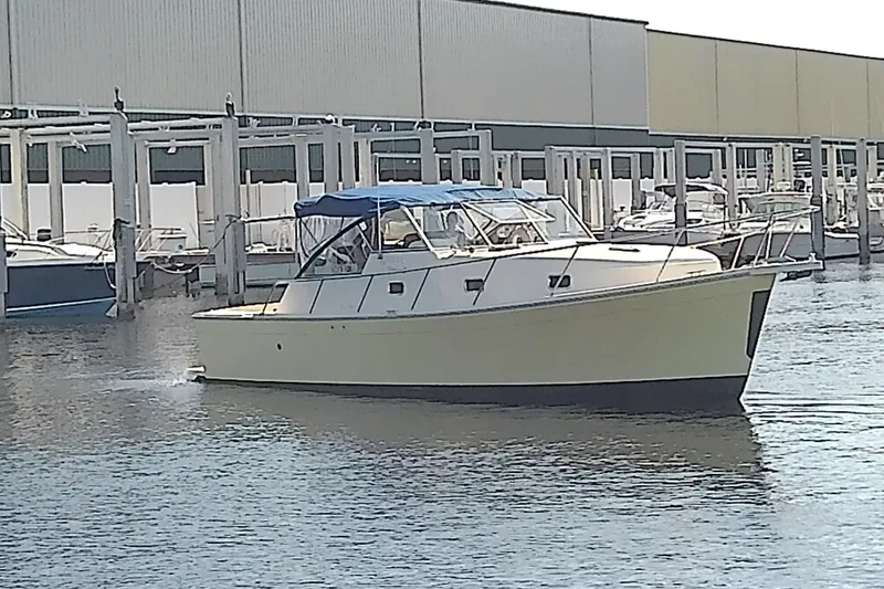 Slide: The Image of 2004 Mainship 34 Pilot II boat docked at marina with blue canopy. - 7