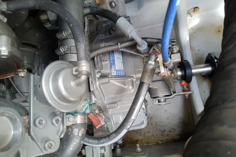 Slide: The Image of Engine components of a 2004 Mainship 34 Pilot II boat, featuring hoses and metal parts. - 70